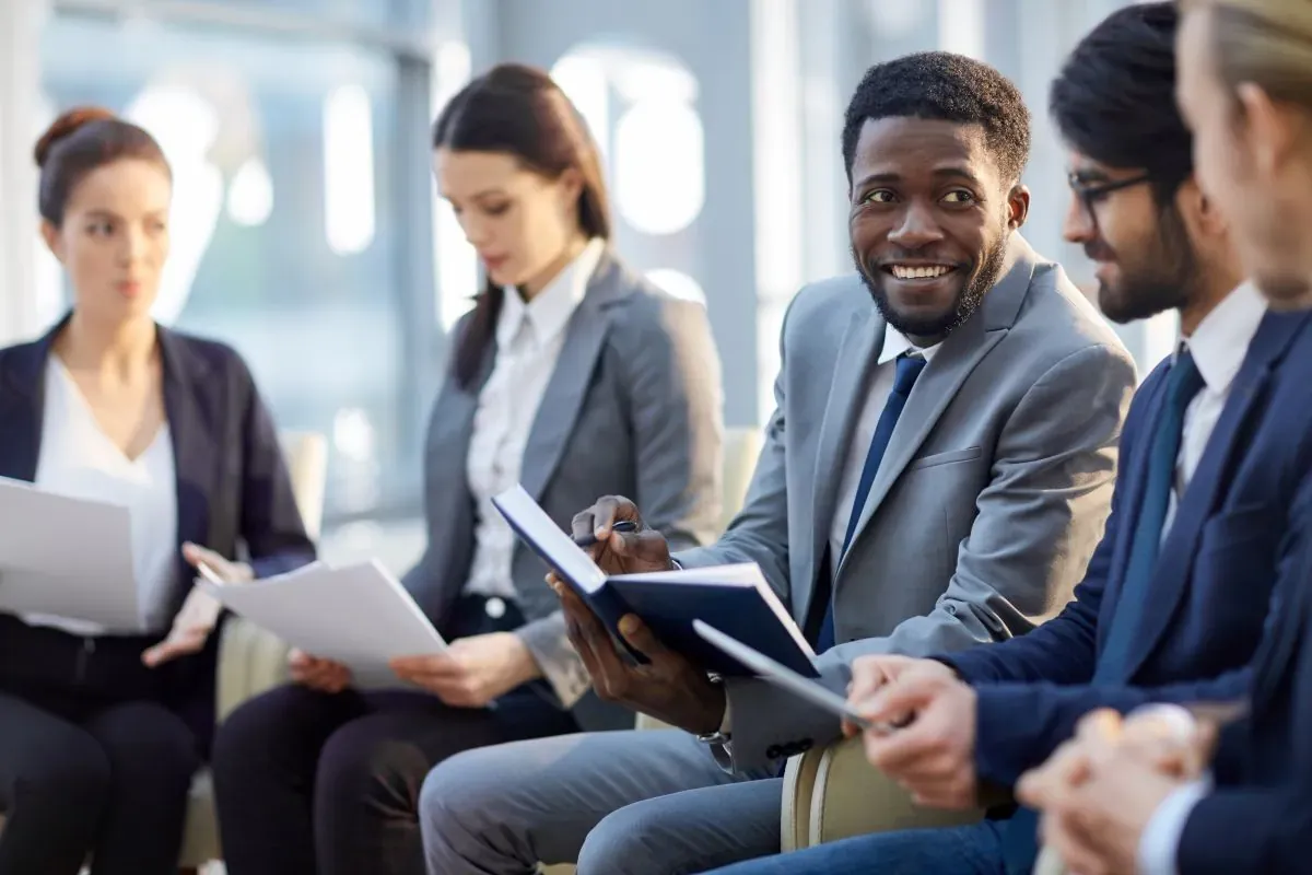 Hiring team in business attire reviewing candidate documents and taking notes during a recruiting meeting